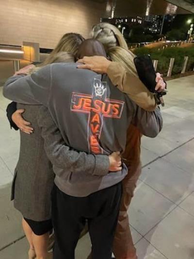 Siaka Massaquoi hugs friends after his release while wearing the 'Jesus Saves' shirt he wore during his bond hearing.