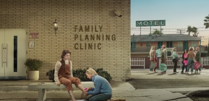 An ad from the 'He Gets Us' campaign titled 'Foot Washing,' which aired during Super Bowl LVIII, includes an image of an older woman washing the feet of a younger woman outside an abortion clinic. 