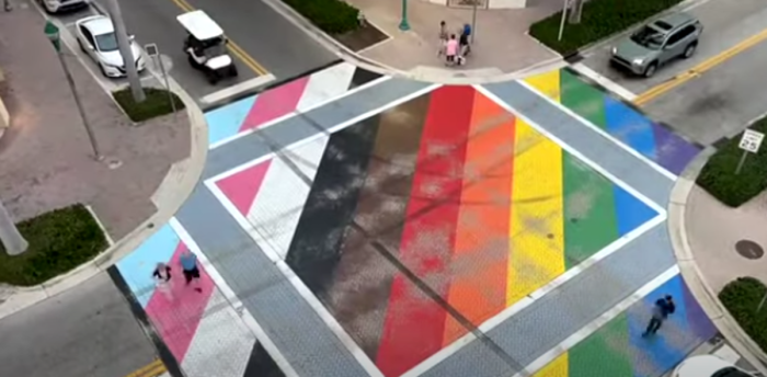 An aerial image shows a variety of tire marks and 'burnouts' from cars driving over the progress pride intersection in Delray Beach, Florida. 