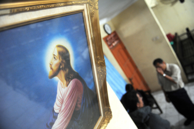 Christian church members wait for news at the church closed by local authorities following months of violence and hostility to the congregation by Muslim vigilantes in Bekasi, outside Jakarta on September 16, 2010.