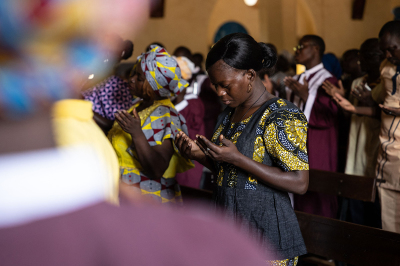 A worshiper prays while attending a mass at Ouagadougou's cathedral in Burkina Faso on June 12, 2022. 