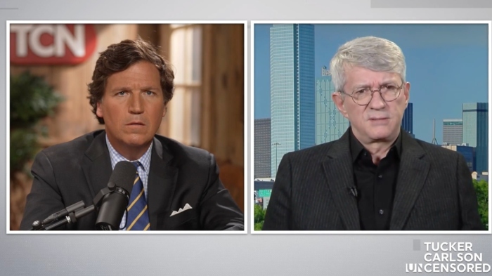 Journalist Steve Baker, right, told Tucker Carlson that he was shackled and placed into a cell with a meth dealer after turning himself in to the FBI over Jan. 6-related charges.