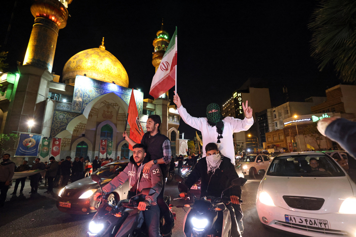 Demonstrators wave Iran's flag and Palestinian flags as they gather at Palestine Square in Tehran on April 14, 2024, after Iran launched a drone and missile attack on Israel. Iran's Revolutionary Guards confirmed early April 14, 2024, that a drone and missile attack was under way against Israel in retaliation for a deadly April 1 drone strike on its Damascus consulate.