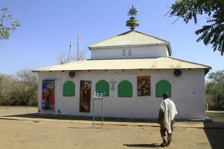 A Sudanese man walks in the courtyard of a church in the Um Gulja former refugee camp in Sudan's eastern Gedaref state on December 15, 2023. Many refugees and asylum seekers fleeing the current war in Khartoum and other areas across Sudan have been seeking refuge in Um Gulja, a refugee camp that was closed down some 20 years ago but with the latest war that broke up in spring 2023 started receiving displaced people again. 