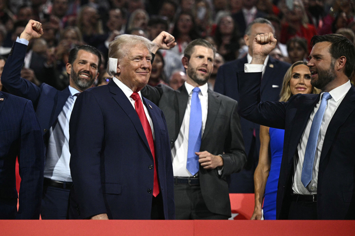 U.S. former President and 2024 Republican presidential candidate Donald Trump (bottom L) smiles as he is cheered on by U.S. Senator from Ohio and 2024 Republican vice-president candidate J. D. Vance (R) and his son's Donald Trump Jr. and Eric Trump during the first day of the 2024 Republican National Convention at the Fiserv Forum in Milwaukee, Wisconsin, July 15, 2024. Donald Trump won formal nomination as the Republican presidential candidate and picked J. D. Vance, a right-wing loyalist for running mate, kicking off a triumphalist party convention in the wake of last weekend's failed assassination attempt. 