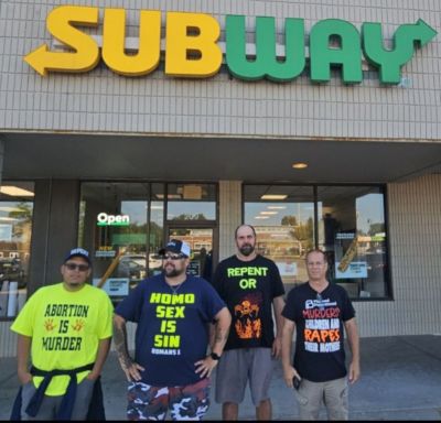 Rich Penkoski, second from left, stands with fellow street preachers outside the Subway in Wisconsin where he and the others allegedly refused service because of the opinions on their shirts.