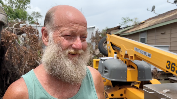 Homeowner Ken Anderson stands outside his home as he is assisted by volunteers from Texans on Mission in the aftermath of Hurricane Beryl in Jones Creek, Texas. 