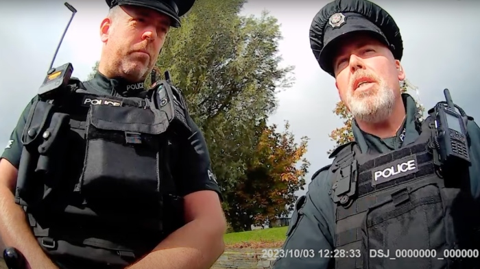 Police officers in Northern Ireland confront Claire Brennan and David Hall outside Causeway hospital in Coleraine, Northern Ireland, on Oct. 3, 2023.