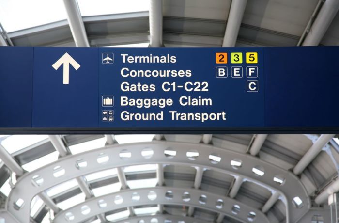 A directional sign is posted inside an airport terminal at Chicago O'hare International Airport in Chicago, Illinois, 