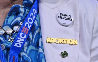 A an attendee wears a 'Abortion' pin on the first day of the Democratic National Convention (DNC) at the United Center in Chicago, Illinois, on August 19, 2024. Vice President Kamala Harris will formally accept the party's nomination for president at the DNC which runs from August 19-22 in Chicago.