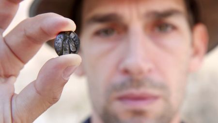 A man holds up a 2,700-year-old seal found in the City of David National Park in Jerusalem. 