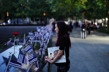 Mercedes Arias pauses near the name of her father, Joseph Amatuccio, at the South Tower reflecting pool of the 9/11 Memorial during the 23rd anniversary of the September 11 terror attack on the World Trade Center at Ground Zero, in New York City on Sept. 11, 2024. 