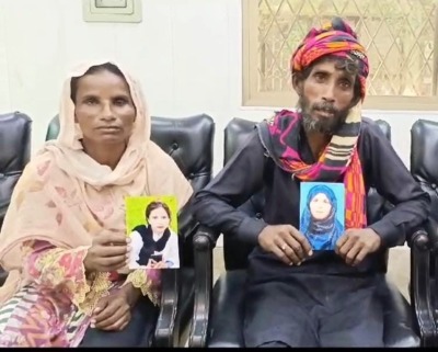 Sumera Bibi and her husband with portraits of their forcibly converted and married daughters who were kidnapped in Kasur District, Pakistan, on July 23, 2024. 