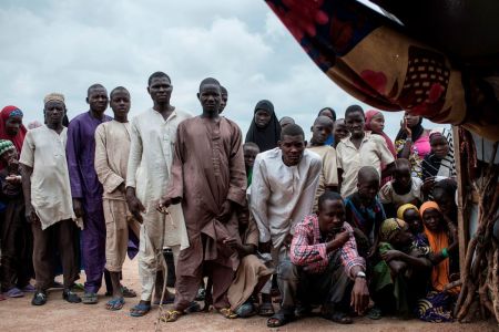 People gather outside a tent in one of the IDP (Internally Displaced People) camps in Pulka, Nigeria, on August 1, 2018. -(Photo by Stefan HEUNIS / AFP) (Photo credit should read STEFAN HEUNIS/AFP via Getty Images) 