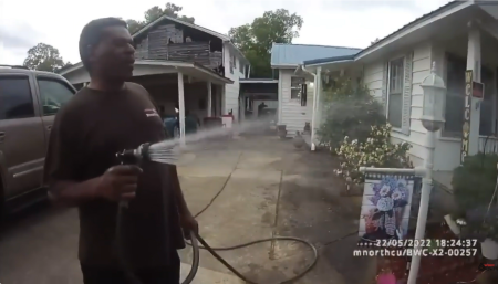 A screenshot from bodycam video released by the Childersburg Police Department shows Pastor Michael Jennings watering his neighbors flowers in Childersburg, Ala., May 22, 2022, shortly before his arrest.