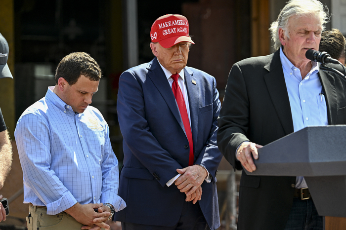 Former U.S. President and Republican presidential candidate Donald Trump bows his head as Franklin Graham (R) leads the group in prayer during a news conference in the aftermath of powerful storm Helene at Chez What furniture store in Valdosta, Ga., Sept. 30, 2024. 