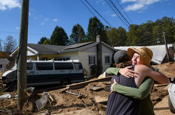 Emily Ogburn, right, hugs her friend Cody Klein after he brought her a meal on Oct. 2, 2024, in Swannanoa, N.C. Ogburn's home was spared and she spent the morning of the storm helping and comforting neighbors who had found shelter on a neighbor's porch. 