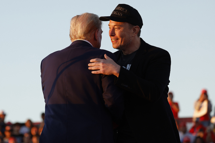 Elon Musk embraces Republican presidential nominee, former President Donald Trump during a campaign rally at the Butler Farm Show fairgrounds on Oct. 05, 2024, in Butler, Pennsylvania. This is the first time that Trump has returned to Butler since he was injured during an attempted assassination on July 13. 