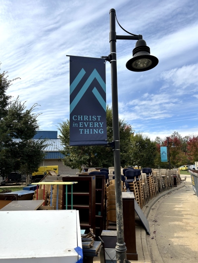 Furniture salvaged from the flood-damaged buildings of Asheville Christian Academy in Swannanoa, N.C., was piled beneath a banner displaying the school's motto, 'Christ in Every Thing,' on Oct. 15, 2024.