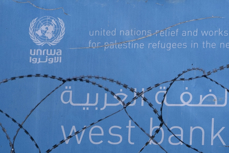 Barbed wire is seen in front of a sign located at the entrance to Jerusalem branch of UNWRA on Oct. 29, 2024, in Jerusalem. Israeli lawmakers voted on Monday to ban the U.N. agency for Palestinian Refugees (UNRWA) from carrying out any activity in the country. Following the vote, Israel's Knesset passed a second bill to sever diplomatic ties with the organization.