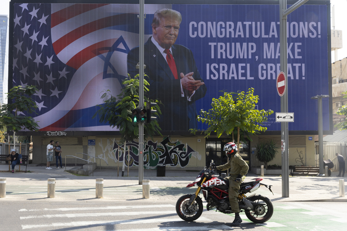 People pass by a congratulatory billboard showing elected U.S. President Donald Trump on Nov. 7, 2024, in Tel Aviv, Israel. In a post on X, Israeli Prime Minister Benjamin Netanyahu has congratulated Donald Trump on 'history's greatest comeback,' following Trump's victory in the U.S. Presidential election. During his first term in office, Trump implemented pro-Israel policies, including moving the U.S. Embassy from Tel Aviv to Jerusalem. 