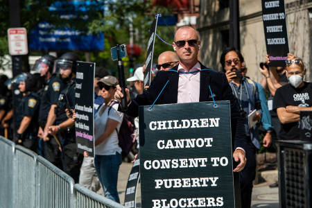 Father and activist Chris Elston, joined by supporters, demonstrates against prescribing puberty blockers, cross-sex hormones and body-mutilating surgeries on minors, such as double mastectomies and castration, outside of Boston Children's Hospital in Boston, Massachusetts, on Sept. 18, 2022. - Protestors for and against the hospital's programs that perform genital mutilation surgeries and dispense irreversible hormones were gathered outside the hospital. 