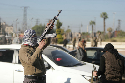 An anti-government fighter fires into the air in a street in Aleppo on Nov. 30, 2024. Jihadists and their Turkish-backed allies breached Syria's second city of Aleppo on Nov. 29, as they pressed a lightning offensive against forces of the Iranian- and Russian-backed government. 