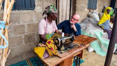 Global Christian Relief President and CEO David Curry speaks to a woman in Nigeria about her small sewing business. 