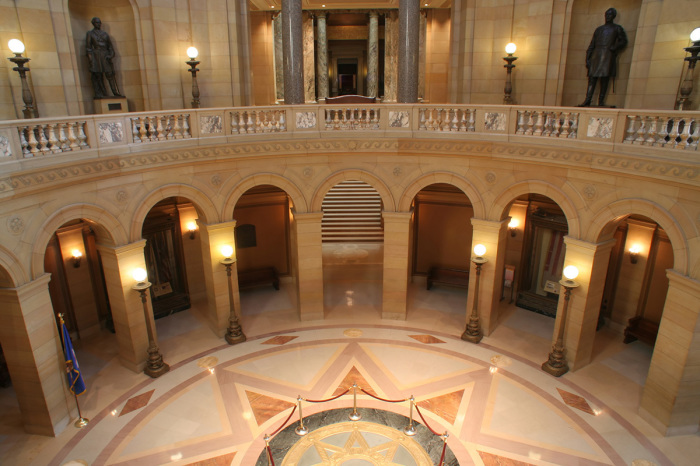 The Minnesota Capitol building interior, featuring the rotunda balcony under the circular dome area. The architecture houses the state Senate, House of Representatives, Attorney General, the office of the Governor, and the Supreme Court of Minnesota.