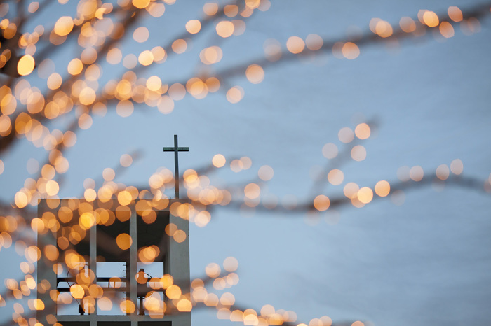 Church tower with crucifix and Christmas lights in The Hague, Netherlands. 