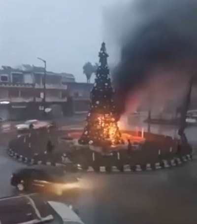 A Christmas tree is on fire in the town of Al-Suqalabiyah near the city of Hama, Syria, on Dec. 23, 2024. 