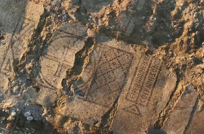 The mosaic, featuring a cross and an inscription at its center. 