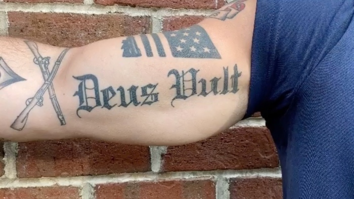 A photo of Pete Hegseth's bicep tattooed with the Latin phrase 'Deus Vult,' which dates back to the First Crusade but has been cited as an alleged white supremacist dogwhistle.