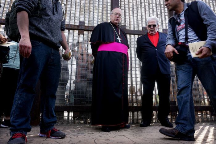 Robert W. McElroy, archbishop of San Diego, waits to speak with participants through the fence during the 23rd Posada Sin Fronteras where worshipers gather on both sides of the US-Mexican border fence for a Christmas celebration, at Friendship Park and Playas de Tijuana in San Ysidro, California on December 10, 2016. 