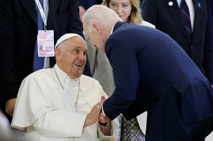 Pope Francis (L) speaks with U.S. President Joe Biden (R) as Italy's Prime Minister Giorgia Meloni (rear) looks on, on the sidelines of a working session on Artificial Intelligence (AI), Energy, Africa-Mediterranean at the Borgo Egnazia resort during the G7 Summit in Savelletri near Bari, Italy, on June 14, 2024.