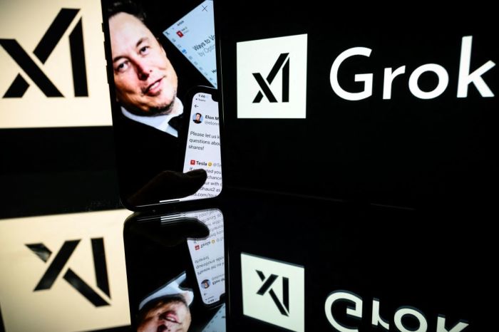 This photograph taken on Jan. 13, 2025, in Toulouse shows screens displaying the logo of Grok, a generative artificial intelligence chatbot developed by xAI, the American company specializing in artificial intelligence and it's founder South African businessman Elon Musk. 