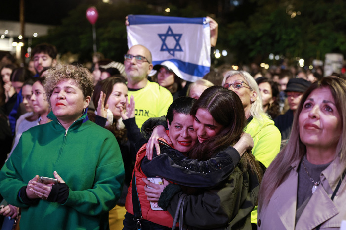 Supporters and relatives of hostages held captive in the Gaza Strip since the Oct. 7, 2023, attacks by Palestinian militants, react while watching a live television broadcast on the release of Israeli hostages, at the Hostages Square in Tel Aviv, on Jan. 19, 2025. The crowds in Tel Aviv's 'Hostage Square' cheered and whooped with joy late on Jan. 19 at the news that the first three hostages freed under the Gaza ceasefire deal had returned to Israel. 