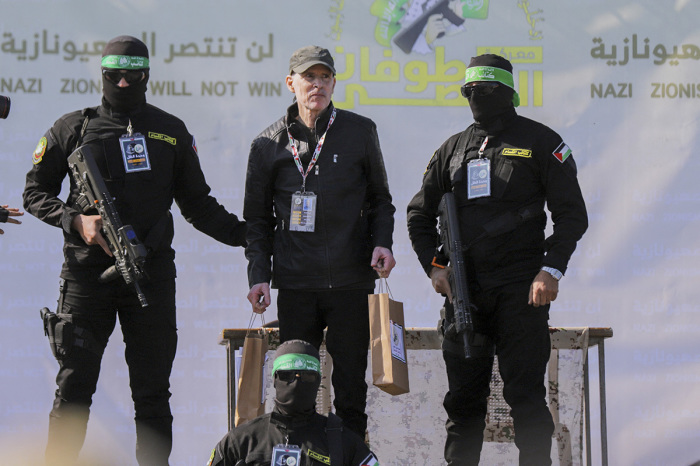 Palestinian militant group Hamas fighters escort American-Israeli hostage Keith Siegel on a stage before handing him over to a Red Cross team in Gaza City on Feb. 1, 2025, as part of the fourth hostage-prisoner exchange.