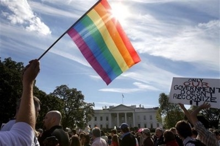 Gay rights advocates march by the White House in Washington, on Sunday, Oct. 11, 2009. Thousands of gay rights supporters marched Sunday from the White House to the Capitol, demanding that President Barack Obama keep his promises to allow gays to serve openly in the military and work to end discrimination against gays.