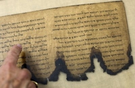 A worker of the IAA, Israel Antiquities Authority, points at a fragment of the Dead Sea Scrolls in a laboratory in Jerusalem, Oct. 19, 2010. 