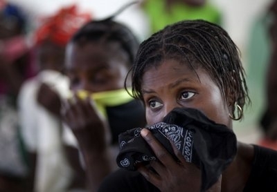 Women cover their mouths and noses as they wait for their children suffering cholera symptoms to be treated at the hospital in Grande-Saline, Haiti, Saturday, Oct. 23, 2010. A spreading cholera outbreak in rural Haiti threatened to outpace aid groups as they stepped up efforts Saturday hoping to keep the disease from reaching the camps of earthquake survivors in Port-au-Prince. Health officials said at least 208 people had died.