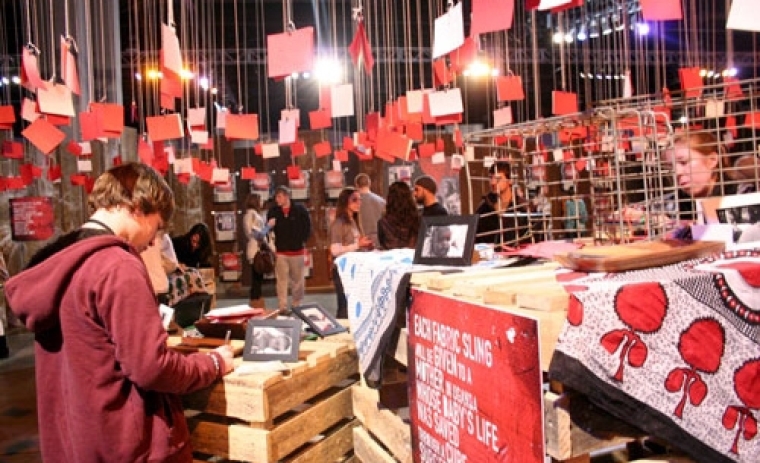 Red cards hang from the rafters at the Cure International station where Passion 2011 students are asked to donate towards life-saving surgery for a baby in Uganda. Each card contains a student message to the babies who suffer from Hydrocephalus, or 'water on the brain,' which causes swelling of the head and results in developmental delay, blindness, and eventually death. Instead of just meeting the goal of raising ,000 to fund 50 surgeries, students provided 1,000 to save the lives of 141 babies.