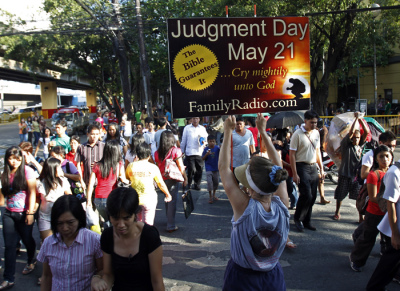 Debra Schaper of Maryland U.S., who is a member of a religious group called Family Radio, displays a placard while spreading the group's prediction that the world will end on May 21, 2011, on the streets in Manila May 13, 2011. The U.S. based Christian group took to the streets of Manila earlier this week to preach that the end of the world is fast approaching on May 21 at sunset, to be precise.