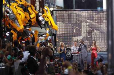 Cast member Tyrese Gibson addresses the crowd in front of Rosie Huntington-Whiteley (R) during the premiere of 'Transformers: Dark of The Moon' in Times Square in New York June 28, 2011.