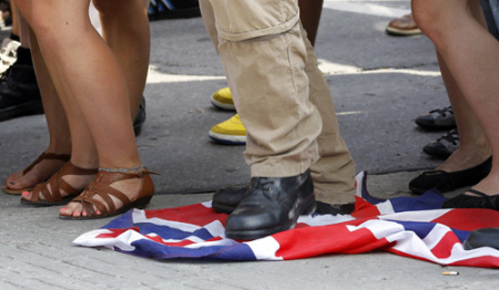 A demonstrator steps on a British Union flag before the arrival of Britain's Prince William and his wife Catherine, Duchess of Cambridge, at the Institut de tourisme et d'hotellerie du Quebec in Montreal July 2, 2011. Prince William and his wife Catherine, Duchess of Cambridge, are on a royal tour of Canada from June 30 to July 8.