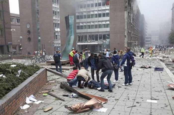 Rescue officials tend to a wounded man after a powerful explosion rocked central Oslo July 22, 2011.