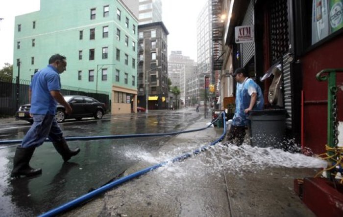 Workers pump out basements in the Soho section of Manhattan after Hurricane Irene passed over the New York City area August 28, 2011. Hurricane Irene battered New York with heavy winds and driving rain on Sunday, knocking out power and flooding some of Lower Manhattan's deserted streets even as it lost some of its strength. Irene was downgraded to a tropical storm on Sunday morning but was still sending waves crashing onto shorelines and flooding coastal suburbs.