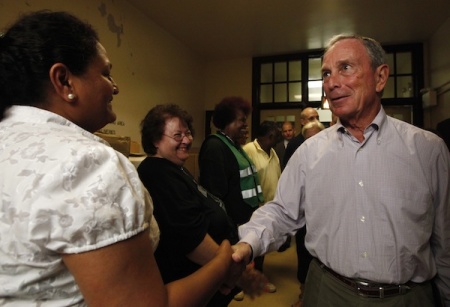 Former New York City Mayor Michael Bloomberg shakes hands with volunteers before a news conference in a shelter center in Queens, New York August 26, 2011. New York City on Friday ordered the evacuation of more than 250,000 people and prepared to shut down its entire mass transit system, both unprecedented measures ahead of the expected battering from Hurricane Irene.