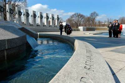 US executive producer and director Steven Spielberg (L) and actor Tom Hanks (R) US Deputy Secretary of Veterans Affairs Scott Gould (2nd L), and former U.S. Senator Elizabeth Dole salute after laying a wreath during ceremony at the National WWII Memorial in Washington, D.C., on March 11, 2010. The ceremony was organized to honor and pay tribute to WWII veterans who served in the Pacific.