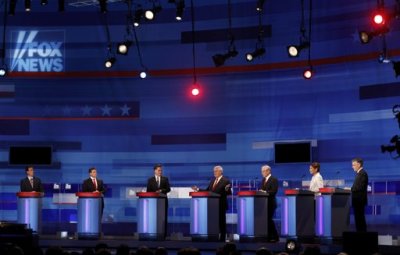 Republican presidential candidates (L-R) former U.S. Senator Rick Santorum (R-PA), Texas Governor Rick Perry, former Massachusetts Governor Mitt Romney, former U.S. Speaker of the House Newt Gingrich (R-GA), U.S. Representative Ron Paul (R-TX), U.S. Representative Michele Bachmann (R-MN), and former Governor of Utah Jon Huntsman attend the Republican Party presidential candidates debate as Gingrich speaks in Sioux City, Iowa, December 15, 2011.